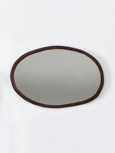 an oval mirror is hanging on the wall