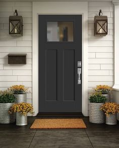 the front door is painted black and has three planters on either side