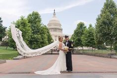 a bride and groom standing in front of the capitol building