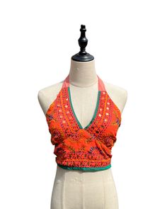 This vibrant, hand-embroidered bikini halter top offers stylish Boho-inspired fashion with its colorful threads and sequin embellishments. Paired with jeans or a skirt, this is the perfect summer top to stand out in and make a statement. The lining is a contrasting color to give it a unique, eye-catching look. One Size Made in India Care Instructions: Dry clean only Girl In The Mirror, Colorful Threads, Inspired Fashion, The Mirror, Summer Top, Bright Orange, Perfect Summer, Bright Pink, Halter Top