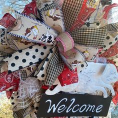 a welcome sign hanging from the side of a tree with burlocks on it