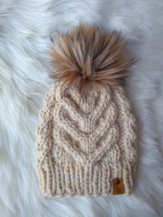 a knitted hat with a fur pom