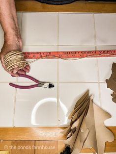 a pair of scissors are being used to cut out paper shapes on the tile floor