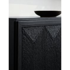 a bowl sitting on top of a black cabinet