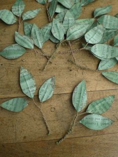 some paper leaves are tied together on a wooden floor with string and twine to make it look like they have been made out of old book pages