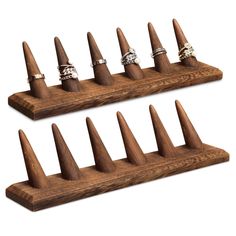 a set of six rings on top of a wooden display holder with four different sizes and shapes