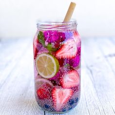 a mason jar filled with sliced strawberries and limes