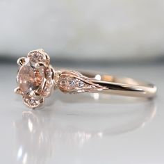 Bloom-VS Diamond and Round Morganite in 14K Rose Gold Comfort Fit Engagement Ring Unique Design Rose Gold Ring. Perfect choice as a wedding, anniversary or stackable ring for everyday wear. *Style # R601E-7mm-Morg-14KRCenter Stone*Natural AAA Quality Morganite*Pinkish peach, Eye-clean (VS1 clarity) *7x7 mm Round Brilliant cut *Approx. gemstone weight: 1.20 caratsSide Stone*Conflict Free Natural White Diamonds*Round Brilliant Cut *F-G color, VS2 clarity*Total diamond weight of 0.35 caratsRing Det Rose Gold Flower Ring With Center Stone For Promise, Delicate Rose Gold Round Cut Ring, Delicate 14k Rose Gold Wedding Rings, Delicate Wedding Rings In 14k Rose Gold, 14k Gold Flower Ring With Halo Setting For Anniversary, Rose Gold Flower Ring With Prong Setting For Promise, Rose Gold Flower Ring With Prong Setting For Anniversary, Delicate Rose Gold Brilliant Cut Wedding Ring, Delicate 14k Rose Gold Anniversary Ring