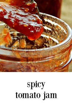 a jar filled with lots of food sitting on top of a table next to a spoon