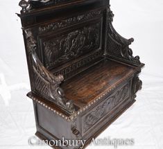 an ornate wooden bench with carvings on the back and sides, sitting against a white background