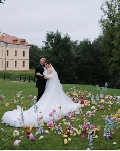 a bride and groom standing in the middle of flowers