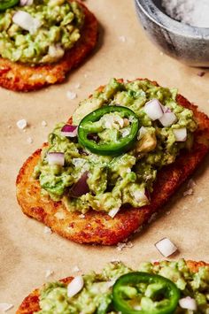 three pieces of bread topped with guacamole and sliced jalapenos