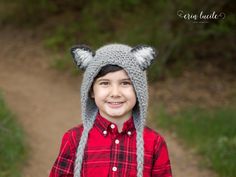 a young boy wearing a knitted wolf hat