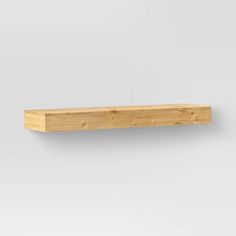 a wooden shelf sitting on top of a white wall