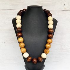 This colorful wood bead necklace was hand beaded using a mix of large 25mm round dark brown, tan, and beige wooden beads in a modern color block design. The necklace measures approximately 28 inches in length and is fastened with a silver clasp. The end result is a cool bohemian piece that fits in perfectly with almost any outfit!  Perfect for any gender.  Length can be adjusted if needed - just ask! Wood represents a sense of earthiness, spirituality, creativity, liberty, prosperity, health, an Adjustable Brown Beaded Necklace, Adjustable Brown Beaded Round Necklace, Adjustable Brown Round Beaded Necklace, Adjustable Round Brown Beaded Necklace, Handmade Brown Beaded Necklaces, Handmade Brown Round Beaded Necklaces, Brown Wooden Beads Jewelry, Brown Wooden Beads Round Jewelry, Brown Round Wooden Beads Jewelry