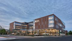 an office building with many windows on the front and side of it's facade