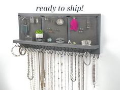 a wall mounted jewelry rack with lots of necklaces and earrings hanging from it's sides