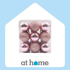 a package of pink and silver ornaments on a blue background with the words at home