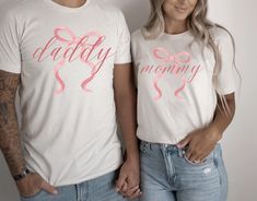 two people standing next to each other wearing matching t - shirts that say daddy and mommy