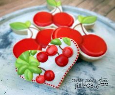 two heart shaped cookies decorated with cherries on a plate