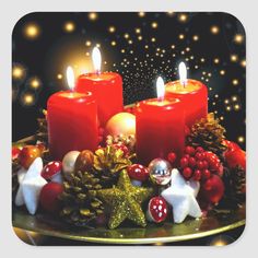 three candles are lit on a plate with christmas decorations and pineconi cones in the foreground