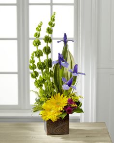 a vase filled with yellow and purple flowers