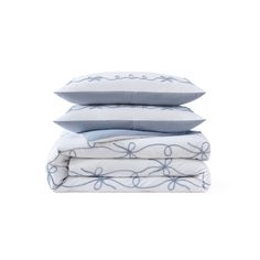 three pillows stacked on top of each other in front of a white background with blue flowers