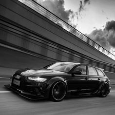 a black and white photo of a car driving down the road