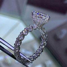 a diamond ring is being held by a pair of tongs