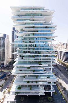 an aerial view of a tall building with many balconies on the top floor