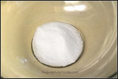 a bowl filled with white sugar on top of a table