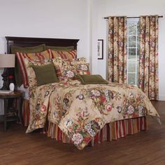 a bed in a room with wooden floors and floral bedspread on top of it