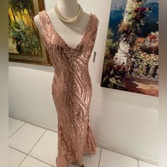 a mannequin wearing a pink dress next to a painting