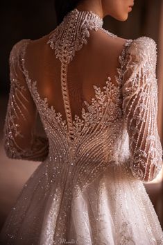 the back of a woman's wedding dress with beading and sequins