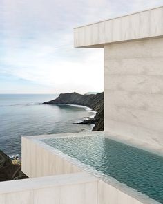 an outdoor swimming pool next to the ocean