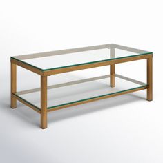 a glass and wood coffee table with shelves on each side, against a white background