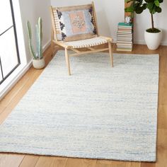 a white and blue rug with a wooden chair next to it