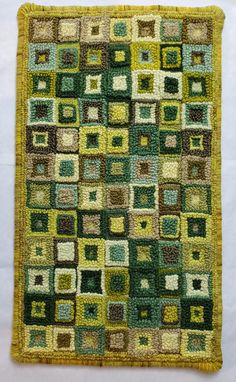 a green and yellow rug with squares on the bottom, in various sizes and colors