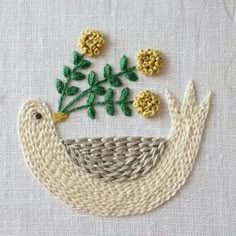 a close up of a piece of cloth with flowers and leaves in the shape of a bird