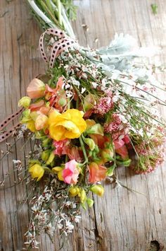 a bunch of flowers sitting on top of a wooden table