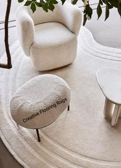 a white chair sitting on top of a rug next to a table with a foot stool