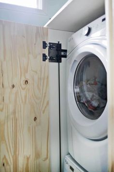 a washer and dryer in a room with wood paneling on the walls