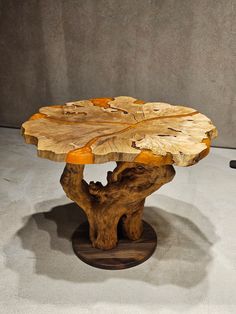 the table is made out of wood and has an unusual design on it's base