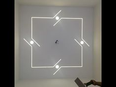 a person is using a laptop computer in a room with white lights on the wall