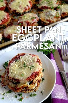 an eggplant parmesan is on a plate next to some silverware