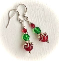 Holiday Christmas Silver Red and Green Dangle Earrings: These festive Christmas/Holiday red and green dangle earrings are made with sterling silver components, round, red crackle glass beads topped with ornamental silver bead caps, green faceted oval beads and red Swarovski crystals. Each earring is carefully wire wrapped and attached to sterling silver French hook ear wires.  Perfect for Christmas gatherings or everyday Holiday wear. Also ideal for a Christmas stocking stuffer, sister gift, dau Christmas Celebration Jewelry Drop Earrings, Christmas Celebration Drop Earrings Jewelry, Christmas Gift Drop Earrings, Holiday Jewelry With Matching Earrings, Christmas Celebration Jewelry With Matching Earrings, Red Jewelry For Christmas Holiday, Festive Christmas Jewelry With Matching Earrings, Holiday Dangle Earrings With Ear Wire, Festive Christmas Earrings