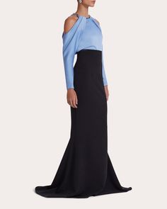 A display of architectural elegance, the Aksha gown frames its crystal-embellished collar with a lustrous satin bodice and draped off-shoulder sleeves. Cinched at the waist, the heavy crepe skirt fits slim throughout the hips and thighs before flaring into a dimensional fishtail hem. Zip closure Draped off-shoulder sleeves Crystal embellished collar Darted seams Fitted waistline Fishtail hem Satin bodice Heavy crepe skirt Self (skirt): 92% polyester, 8% elastane Contrast (bodice): 100% polyester Off-shoulder Evening Dress With Sweep Train For Gala, Luxury Off-shoulder Evening Dress With Fitted Bodice, Evening Dress With Draped Sleeves For Gala, Pre-draped Off-shoulder Formal Gown, Off-shoulder Pre-draped Formal Gown, Glamorous Evening Gown With Draped Sleeves, Evening Gown With Draped Sleeves And Fitted Bodice, Elegant Off-shoulder Gala Evening Dress, Glamorous Formal Evening Dress With Draped Sleeves