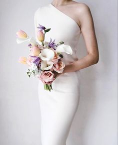 a woman in a white dress holding a bouquet of flowers