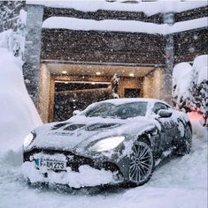 a car parked in front of a house covered in snow