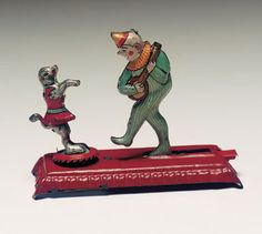 a small figurine of a man playing with a cat on a red base